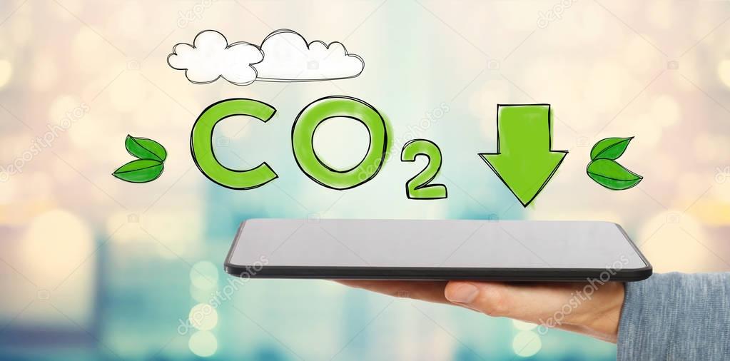 Reduce CO2 with man holding a tablet