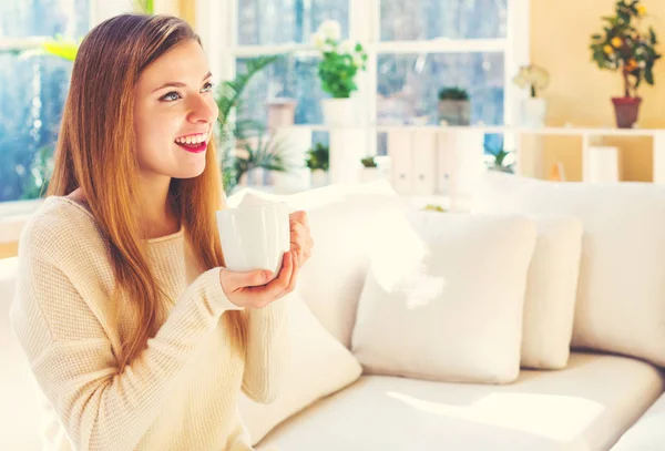 Gelukkige jonge vrouw die koffie drinkt — Stockfoto