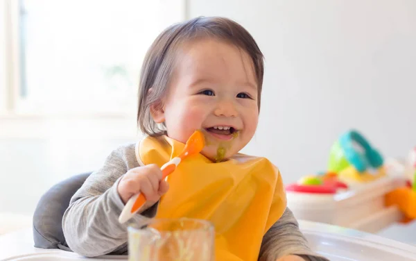 Happy little baby boy eating food — Stock Photo, Image