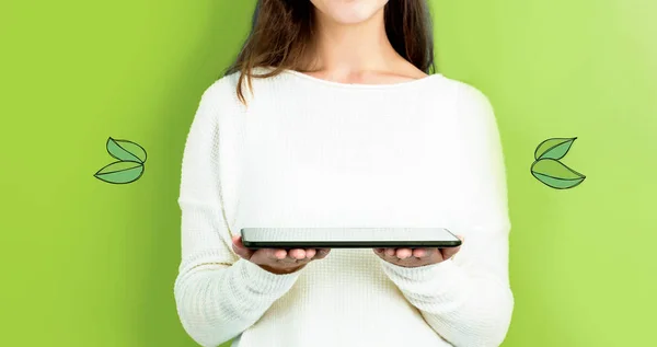 Hojas verdes con mujer sosteniendo una tableta — Foto de Stock