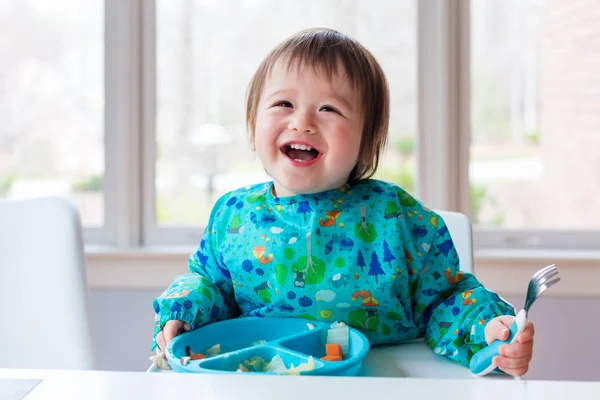 Toddler boy with a big smile eating food — Stock Photo, Image