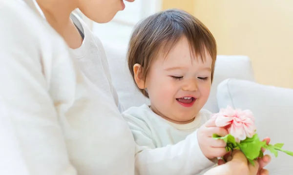 Toddler boy with his mother holding flowers — Stock Photo, Image