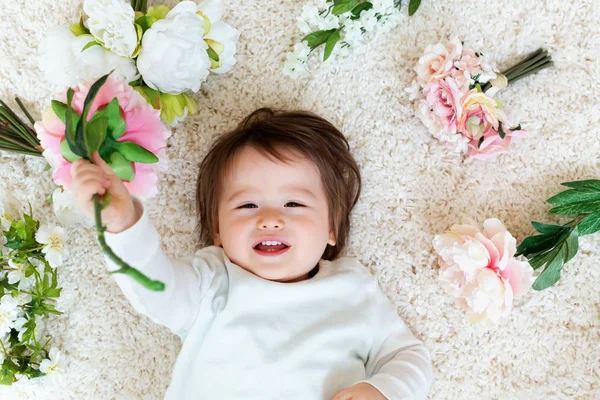 Szczęśliwy toddler chłopiec z wiosennych kwiatów — Zdjęcie stockowe