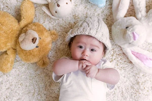 Bambino con i suoi peluche su un tappeto — Foto Stock