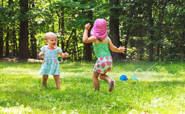 Fröhliche Kleinkind Mädchen spielen in einer Sprinkleranlage — Stockfoto