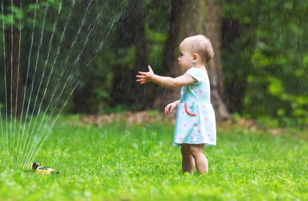 Glücklich Kleinkind Mädchen spielt in einer Sprinkleranlage — Stockfoto