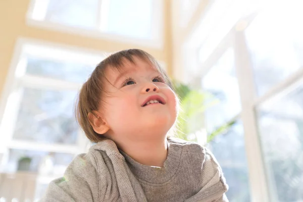 Ευχαρίστως toddler αγόρι χαμογελά σε ένα μεγάλο δωμάτιο — Φωτογραφία Αρχείου