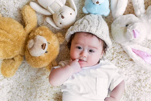 Niño con sus animales de peluche en una alfombra —  Fotos de Stock