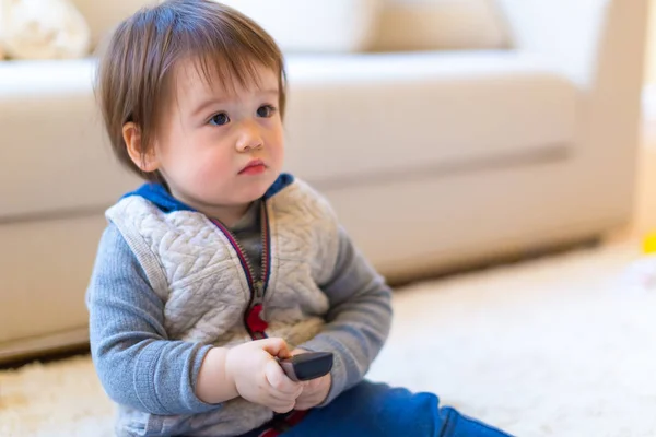 Малыш смотрит телевизор с пультом дистанционного управления — стоковое фото
