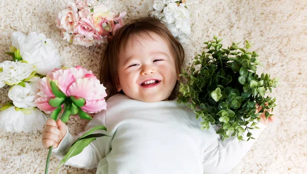 Glada barnet pojke med vårblommor — Stockfoto