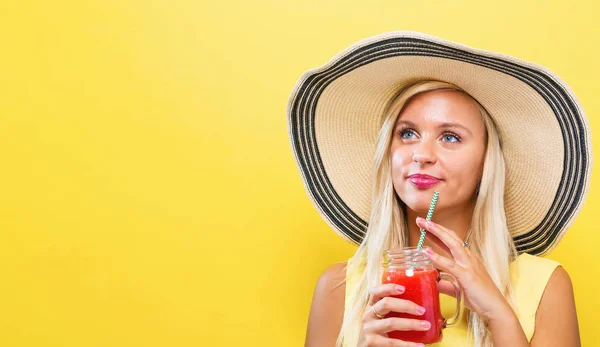 Glückliche junge Frau trinkt Smoothie — Stockfoto