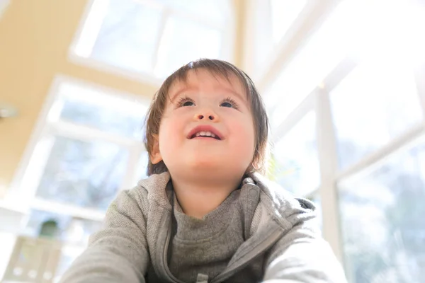 Szczęśliwy toddler chłopiec uśmiecha się w dużym pokoju — Zdjęcie stockowe