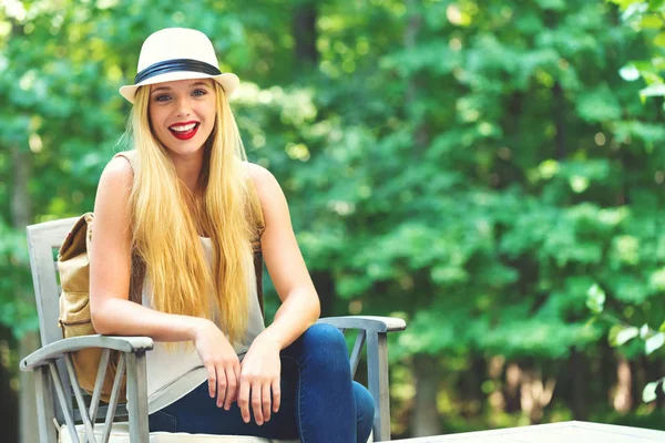 Junge Frau sitzt draußen — Stockfoto