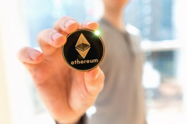 Bir adam tarafından düzenlenen Ethereum cryptocurrency sikke