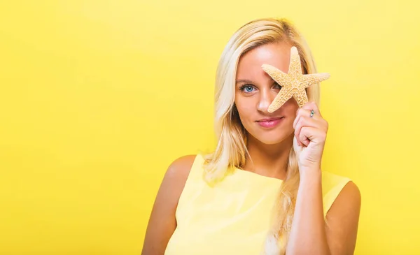 Gelukkig jonge vrouw met een zeester — Stockfoto