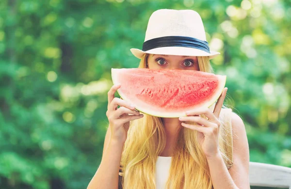 Young woman eating watermelon outside