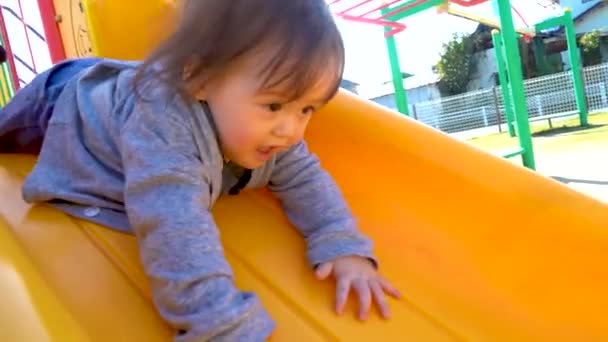 Niño jugando en el patio de recreo — Vídeo de stock