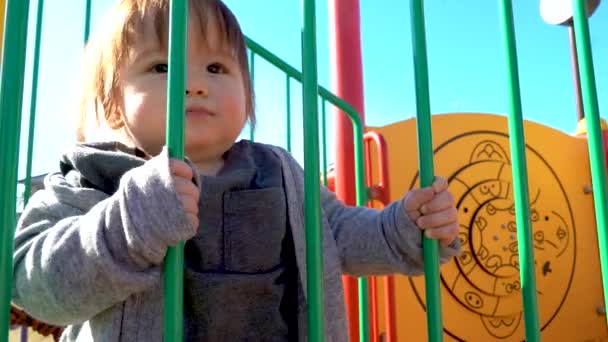 Niño jugando en el patio de recreo — Vídeo de stock
