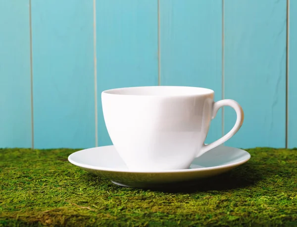 Weiße Kaffeetasse auf grünem Gras — Stockfoto