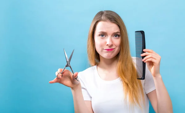 Vrouw met een schaar en kam in de salon hair cutting thema — Stockfoto