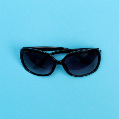 Bebek mavi bir arka plan üzerinde serin güneş gözlüğü