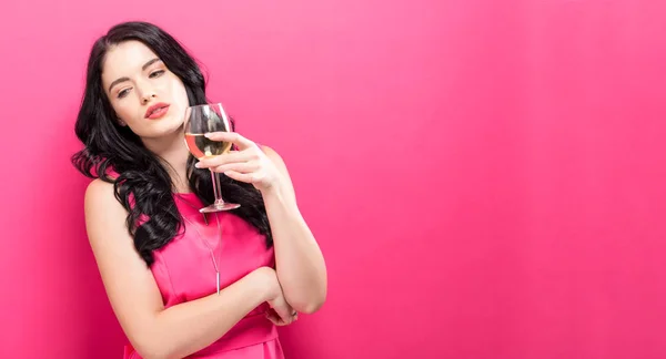 Mujer joven bebiendo vino sobre un fondo sólido — Foto de Stock