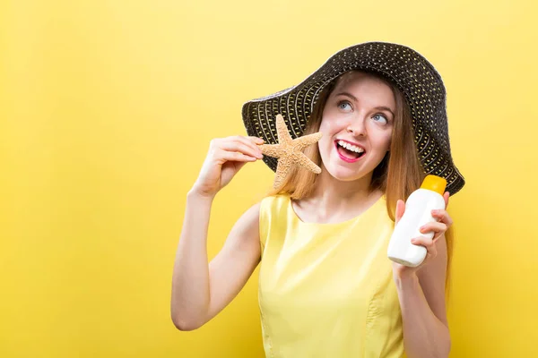 Ung kvinna som håller en flaska solskydd — Stockfoto