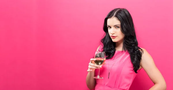 Mujer joven bebiendo vino sobre un fondo sólido —  Fotos de Stock