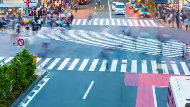 Personer passera berömda korsningen i Shibuya, Tokyo — Stockvideo