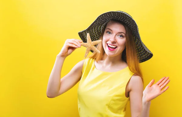 Happy young woman holding a starfish