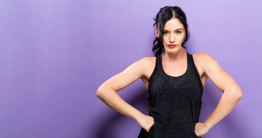 Güçlü genç kadın sağlam bir arka plan üzerine yerleştirmek.