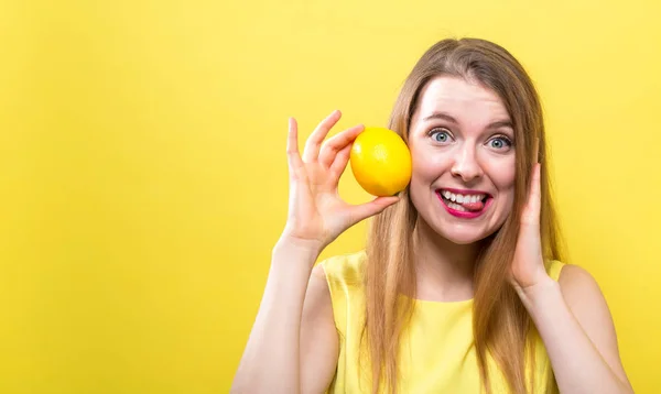 Feliz joven sosteniendo un limón — Foto de Stock