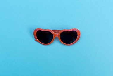 Bebek mavi bir arka plan üzerinde serin güneş gözlüğü