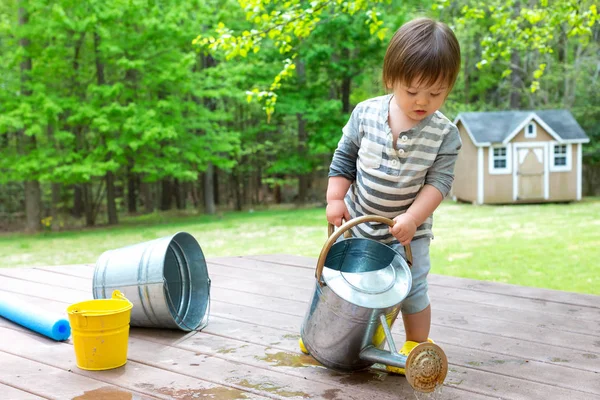 Menino brincando com uma lata de rega — Fotografia de Stock
