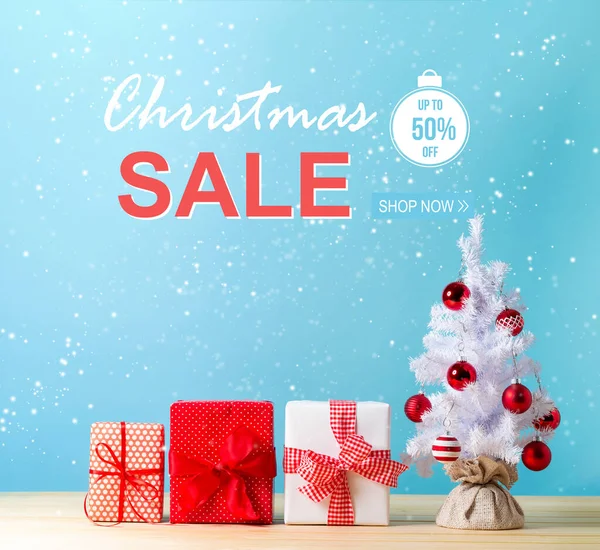 Mensaje de venta de Navidad con un árbol de Navidad y cajas de regalo —  Fotos de Stock
