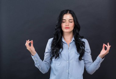 Meditasyon yapan genç bir kadın.