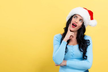 Noel Baba şapkalı genç bayan düşünceli.