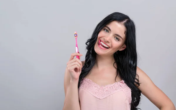 Giovane donna in possesso di uno spazzolino da denti — Foto Stock