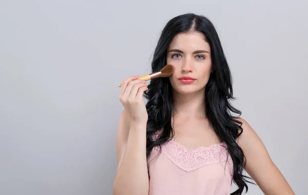 Schöne junge Frau mit Make-up-Set — Stockfoto