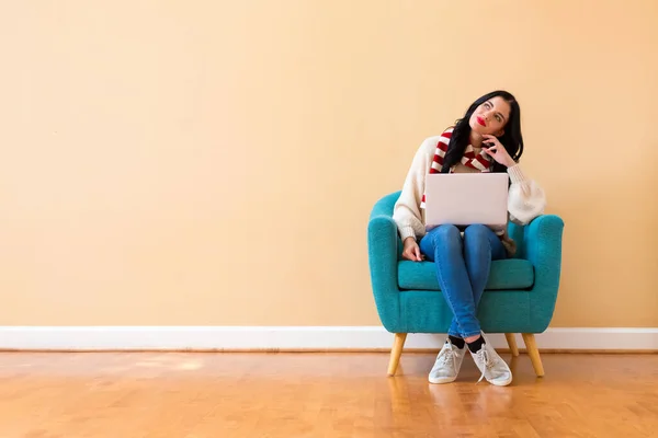 Mujer joven con un ordenador portátil en una pose reflexiva —  Fotos de Stock