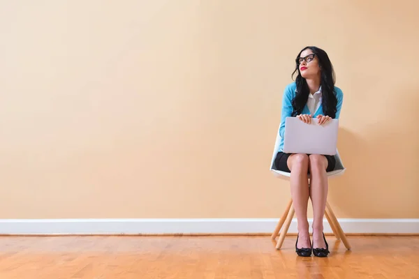 Young woman with a laptop computer in a thoughtful pose — Stock Photo, Image