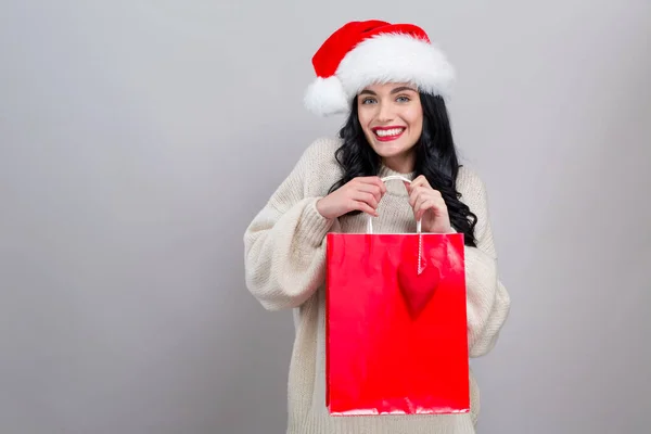 Giovane donna con cappello di Babbo Natale in possesso di una borsa della spesa — Foto Stock