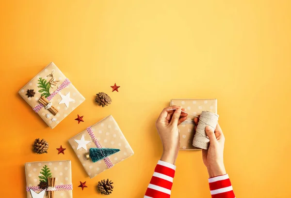 Pessoa fazendo caixas de presente de Natal — Fotografia de Stock