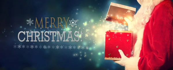 С Рождеством, когда Санта открывает подарочную коробку — стоковое фото