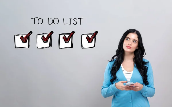 To do list with woman holding a smartphone — Stock fotografie