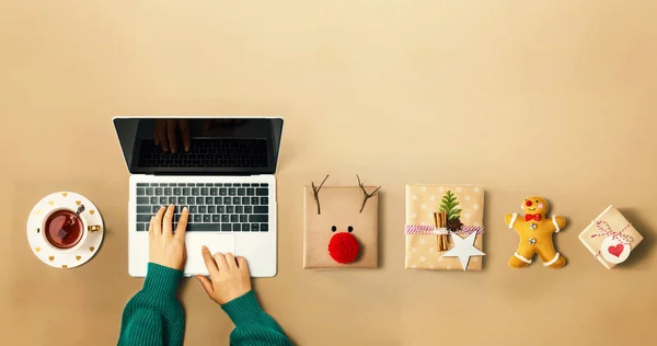 Karácsonyi ajándékdobozok személy segítségével egy laptop — Stock Fotó