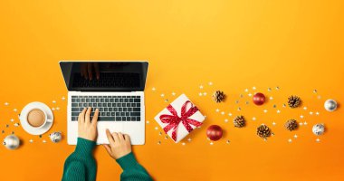 Bir dizüstü bilgisayar kullanan kişinin Noel süsleri