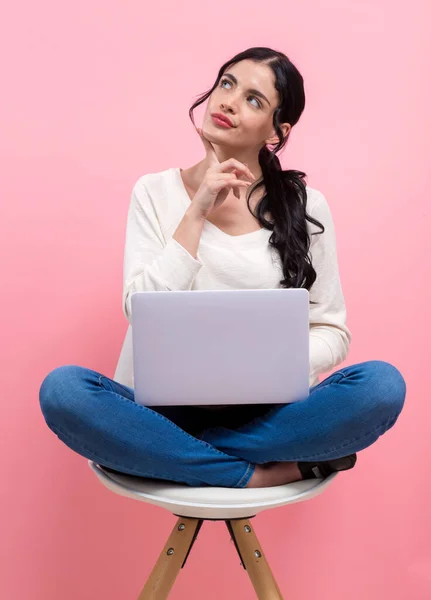 Giovane donna con un computer portatile in una posa premurosa — Foto Stock