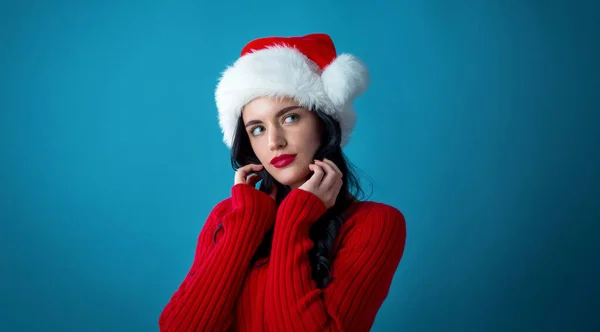 Junge Frau mit Weihnachtsmütze in nachdenklicher Pose — Stockfoto
