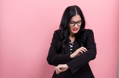 Genç kadın kaşıntılı kolunu tırmalamak.